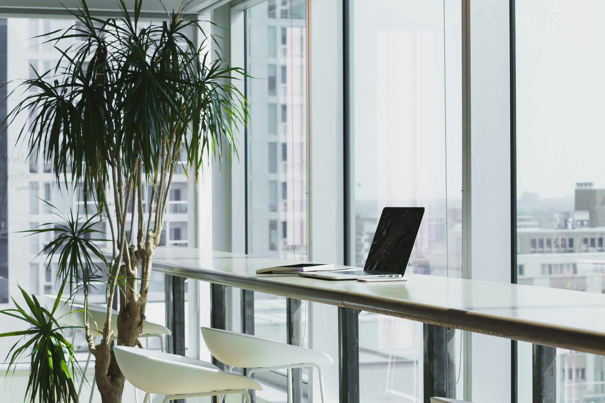 A calm, modern workspace with a laptop by the window